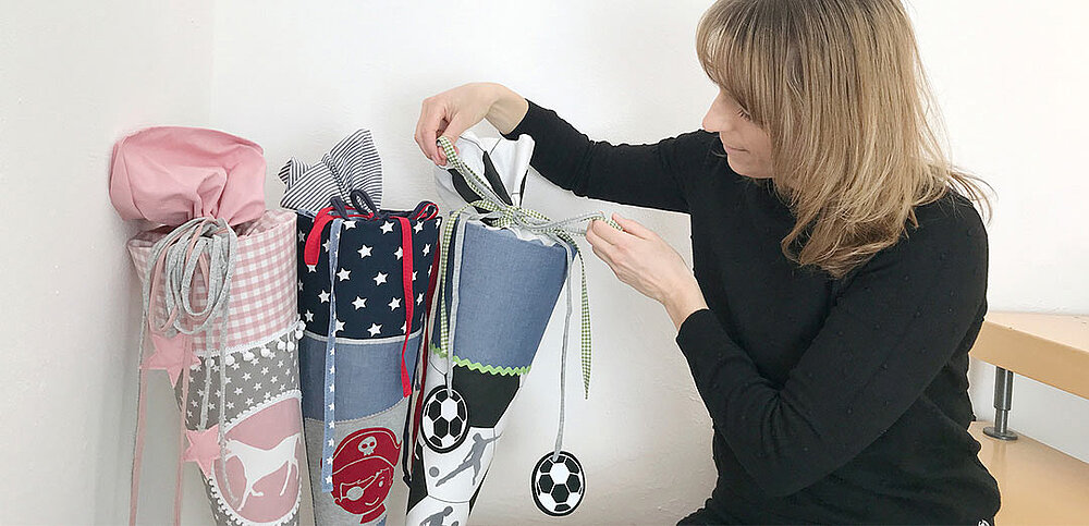 Kollegin neben drei fertiggestellten Schultüten