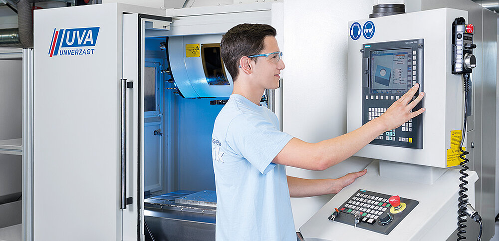 Azubi arbeitet an Maschinenmonitor für Zerspanung