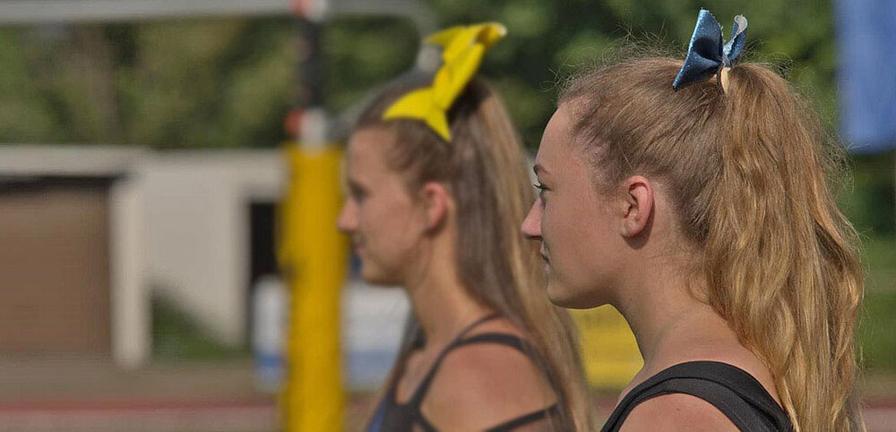 Zwei Cheerleaderinnen mit Schleife im Haar