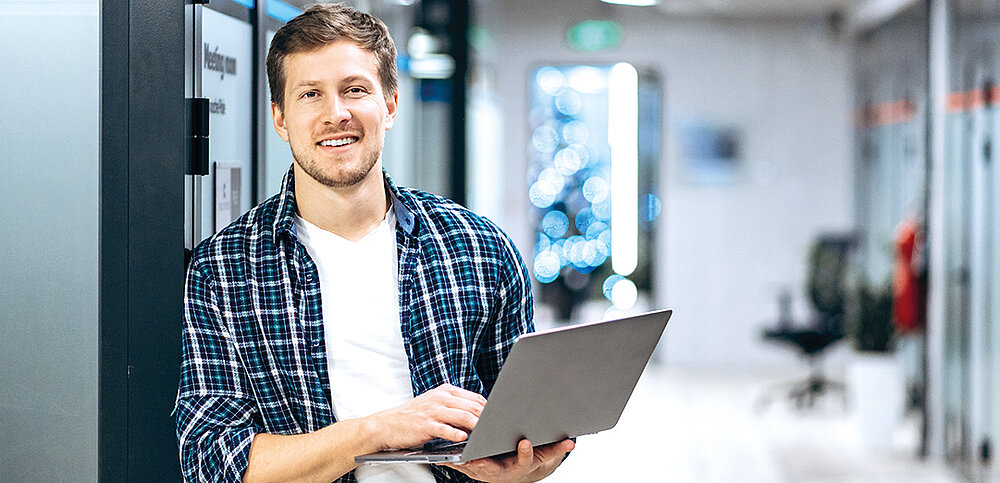 Student mit Laptop in der Hand
