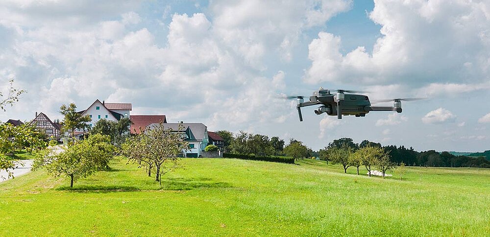Fliegende Drohne über grünen Wiese