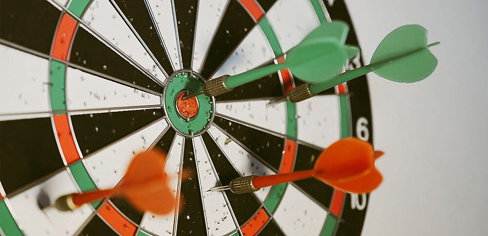 Dartscheibe mit rot und grünen Pfeilen